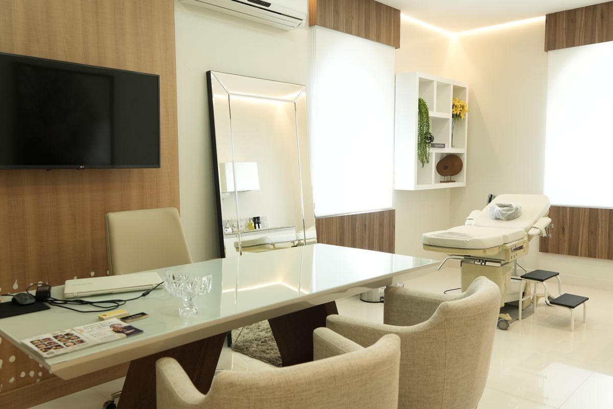 Consultório com mesa de atendimento e maca